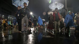 Jas Hujan dan Payung di Car Free Night Malam Tahun Baru Jakarta