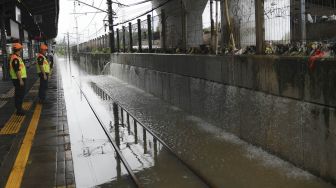 Petugas memeriksa rel kereta api yang terendam banjir di Stasiun KA Tanah Abang, Jakarta, Rabu (1/1). [ANTARA FOTO/Nova Wahyudi]

