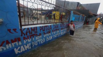 Sejumlah warga berada di jalan yang terendam banjir di kawasan Jatipadang, Pasar Minggu, Jakarta Selatan, Rabu (1/1). [Suara.com/Angga Budhiyanto]
