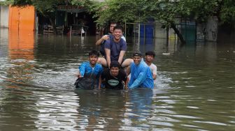 Petugas menata sepeda motor yang terendam banjir di Jalan Daan Mogot, Jakarta Barat, Kamis (2/1). [Suara.com/Angga Budhiyanto] 