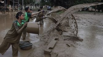 Warga membersihkan endapan lumpur di Perumahan Pondok Mitra Lestari, Bekasi, Jawa Barat, Jumat (3/1). [Suara.com/Angga Budhiyanto]