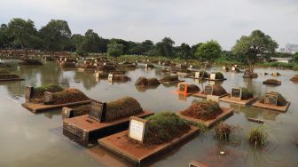 Makam yang terendam banjir di komplek makam TPU Tanah Kusir, Kebayoran Lama, Jakarta Selatan, Jumat (03/01). [Suara.com/Alfian Winanto]
