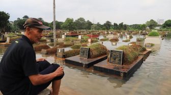 Makam yang terendam banjir di komplek makam TPU Tanah Kusir, Kebayoran Lama, Jakarta Selatan, Jumat (03/01). [Suara.com/Alfian Winanto]
