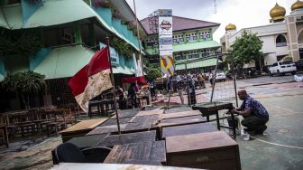 Seorang guru membersihkan meja pascabanjir yang merendam SMA Negeri 8 Jakarta di Bukit Duri, Tebet, Jakarta, Sabtu (4/1).  [ ANTARA FOTO/Aprillio Akbar]