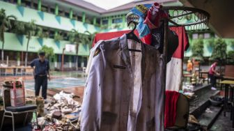 Orang tua siswa mengamati barang yang rusak pascabanjir yang merendam SMA Negeri 8 Jakarta di Bukit Duri, Tebet, Jakarta, Sabtu (4/1). [ ANTARA FOTO/Aprillio Akbar]