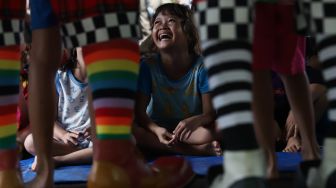 Ekspresi anak-anak korban banjir saat dihibur oleh sejumlah badut yang tergabung dalam komunitas Aku Badut Indonesia (ABI) di posko pengungsian Komplek IKPN Bintaro, Pesanggrahan, Jakarta Selatan, Minggu (5/1). [Suara.com/Angga Budhiyanto]