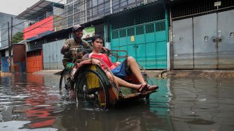 Pengayuh Becak Berjibaku Terobos Banjir di Teluk Gong