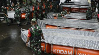 Anggota TNI mengangkat perahu rakit Kodam XIV Hasanuddin saat penyerahaan di Makassar, Sulawesi Selatan, Sabtu (4/1). [ANTARA FOTO/Abriawan Abhe]