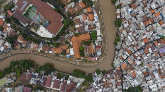 Foto udara suasana wilayah bantaran sungai Ciliwung di kawasan Bukit Duri, Jakarta, Minggu (5/1). [ANTARA FOTO/Muhammad Adimaja]