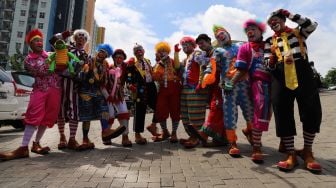 Foto bersama para badut komunitas Aku Badut Indonesia (ABI) bersama dengan anak-anak korban banjir di posko pengungian bencana banjir Gor  Pengadegan, Jakarta Selatan, Selasa (07/01). (suara.com/Alfian Winanto)