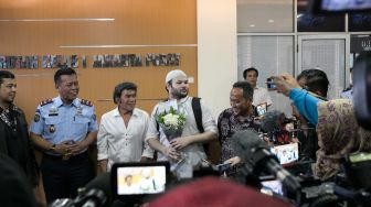 Aktor sekaligus penyanyi Ridho Rhoma didampingi ayahnya Rhoma Irama ketika keluar dari Rutan Salemba, Jakarta Pusat, Rabu (08/01). [Suara.com/Alfian Winanto