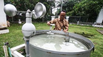 Petugas Badan Meteorologi, Klimatologi dan Geofisika (BMKG) memantau alat pengukur curah hujan di halaman gedung BMKG, Jakarta, Jumat (10/1). [ANTARA FOTO/Rivan Awal Lingga]