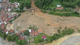 Foto udara anggota tim SAR gabungan melakukan pencarian korban tanah longsor dan banjir bandang yang masih belum ditemukan di Kampung Sinar Harapan, Desa Harkat Jaya, Kecamatan Sukajaya, Kabupaten Bogor, Jawa Barat, Sabtu (11/1). [ANTARA FOTO/Galih Pradipta]