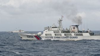 Kapal Coast Guard China-5202 dan Coast Guard China-4301 membayangi KRI Usman Harun-359 saat melaksanakan patroli mendekati kapal nelayan pukat China yang melakukan penangkapan ikan di ZEE Indonesia Utara Pulau Natuna, Sabtu (11/1). [ANTARA FOTO/M Risyal Hidayat]