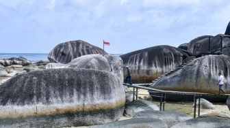 Sejumlah pengunjung melintas diantara bongkahan batu granit di Alif Stone Park, Desa Sepempang, Kabupaten Natuna, Provinsi Kepulauan Riau, Senin (13/1). [ANTARA FOTO/M Risyal Hidayat]