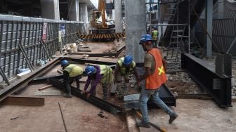 Pekerja menyelesaikan proyek jembatan layang integrasi antara Stasiun MRT ASEAN dengan Halte Centrale Stichting Wederopbouw (CSW) koridor 13 di Jakarta, Selasa (14/1). [Suara.com/Angga Budhiyanto]