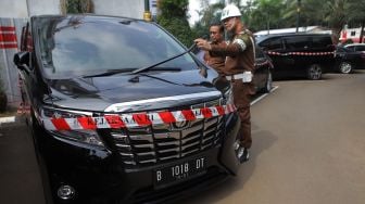 Petugas Kejaksaan Agung RI memeriksa barang bukti sitaan kasus korupsi PT Asuransi Jiwasraya (Persero) yang terpakir di Gedung Tindak Pidana Khusus, Kejaksaan Agung RI, Jakarta, Jumat (17/1).  [ANTARA FOTO/Reno Esnir]
