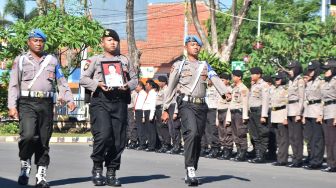 Personel Polri membawa foto AKP Heru Nurtjahyono saat upacara Pemberhentian Tidak Dengan Hormat (PTDH) di halaman Mapolresta Madiun, Jawa Timur, Jumat (17/1).  [ANTARA FOTO/Siswowidodo]