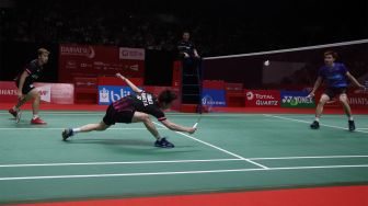 Pebulu tangkis ganda putra Indonesia Marcus Fernaldi Gideon dan rekannya Kevin Sanjaya Sukamuljo mengembalikan kok ke arah lawannya asal Malaysia Aaron Chia dan Soh Wooi Yik dalam babak semifinal Daihatsu Indonesia Masters 2020 di Istora Senayan, Jakarta, Sabtu (18/1). [Suara.com/Angga Budhiyanto]