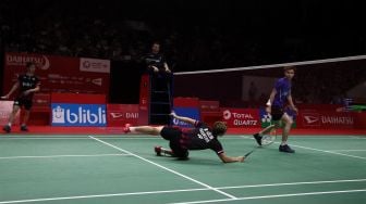 Pebulu tangkis ganda putra Indonesia Marcus Fernaldi Gideon dan rekannya Kevin Sanjaya Sukamuljo mengembalikan kok ke arah lawannya asal Malaysia Aaron Chia dan Soh Wooi Yik dalam babak semifinal Daihatsu Indonesia Masters 2020 di Istora Senayan, Jakarta, Sabtu (18/1). [Suara.com/Angga Budhiyanto]