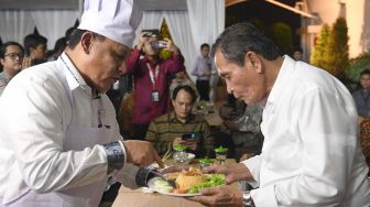 Ketua KPK Firli Bahuri (kiri) memberikan nasi goreng hasil masakannya kepada Ketua Dewan Pengawas KPK Tumpak Hatorangan Panggabean (kanan) di sela-sela Silaturahmi Pimpinan KPK dan Dewan Pengawas KPK di gedung KPK, Jakarta, Senin (20/1). ANTARA FOTO/M Risyal Hidayat