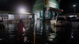 Warga berjalan di sekitar Rumah Sakit Umum Daerah (RSUD) Kraton yang tergenang banjir di Pekalongan, Jawa Tengah, Senin (20/1) malam.  [ANTARA FOTO/Harviyan Perdana Putra]