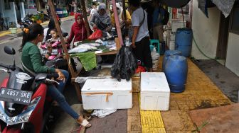 Pedagang dan pembeli bertransaksi di atas trotoar Jalan Sulaiman, Rawa Belong, Jakarta Barat, DKI Jakarta, Rabu (22/1).  [ANTARA FOTO/Aditya Pradana Putra]
