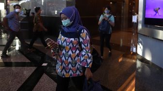 Sejumlah karyawan menggunakan masker saat keluar dari kantor Bank BRI, Jakarta, Kamis (23/1). [Suara.com.Angga Budhiyanto]