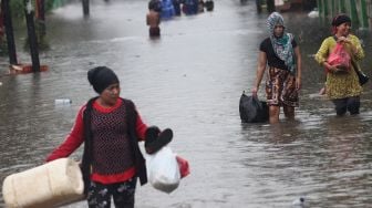 Sejumlah warga melintasi jalan yang terendam banjir di kawasan Duren Tiga, Jakarta Selatan, Jumat (24/1). [Suara.com/Angga Budhiyanto]