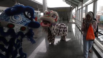 Barongsai menghibur calon penumpang di Stasiun LRT Boulevard Utara, Kelapa Gading, Jakarta Utara, Sabtu (25/1). [Suara.com/Angga Budhiyanto]