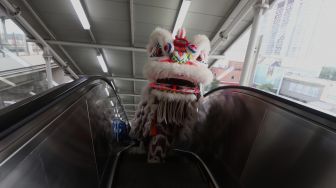 Barongsai beraksi di Stasiun LRT Boulevard Utara, Kelapa Gading, Jakarta Utara, Sabtu (25/1). [Suara.com/Angga Budhiyanto]