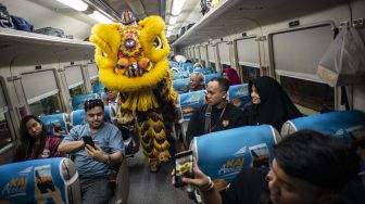 Barongsai beraksi di dalam salah satu rangkaian gerbong KA Bima di Stasiun Gambir, Jakarta, Sabtu (25/1).  [ANTARA FOTO/Aprillio Akbar]