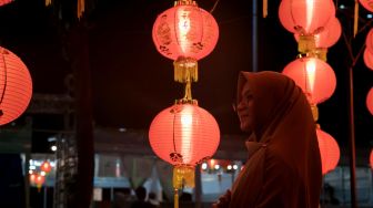 Pengunjung berswafoto di area Thamrin 10 yang di hiasi instalasi lampion dalam rangka merayakan Tahun Baru Imlek di Jakarta Pusat, Minggu (26/1). [Suara.com/Alfian Winanto]