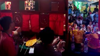 Dalang memainkan Wayang Potehi di Area Thamrin 10, Jakarta Pusat, Minggu (26/01). [Suara.com/Alfian Winanto]