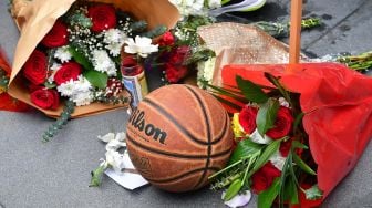 Bunga dan Bola Basket berada di luar Stpales Center untuk mengenang Kobe Bryant di Los Angeles Lakers, Amerika, Minggu (26/1).  [Frederic J. Brown / AFP]