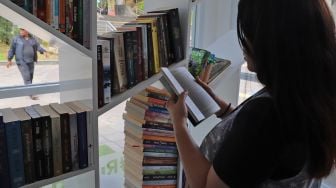 Pengunjung yang sedang membac buku di Ruang Baca Jakarta di Stasiun BNI City, Jakarta Pusat, Rabu (29/01).[Suara.com/Alfian Winanto]
