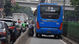 Pengendara sepeda motor berusaha menghindari razia Polisi lalu lintas di jalur khusus Transjakarta Sultan Agung, Manggarai, Jakarta, Jumat (31/1).  [Suara.com/Angga Budhiyanto]