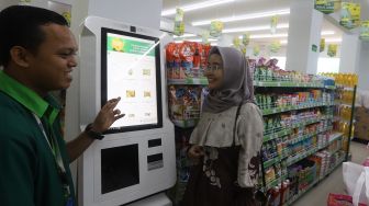 Seorang pelayan melayani pembeli yang berbelanja di Multi Usaha Syariah (MUS) Halal Convenience Store, Meruyung, Depok, Jawa Barat, Minggu (2/2). [Suara.com/Angga Budhiyanto]