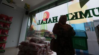 Seorang pembeli berbelanja di Multi Usaha Syariah (MUS) Halal Convenience Store, Meruyung, Depok, Jawa Barat, Minggu (2/2). [Suara.com/Angga Budhiyanto]