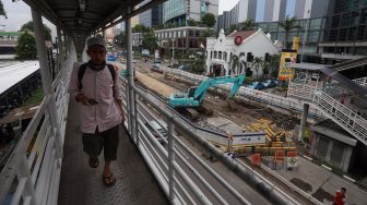 Seorang warga melintas di dekat proyek pembangunan underpass Senen Extension di Pasar Senen, Jakarta, Senin (3/2). [Suara.com/Angga Budhiyanto]