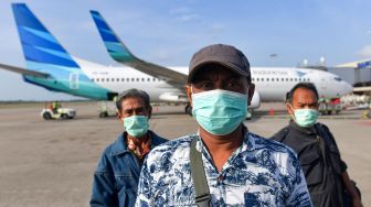 Penumpang maskapai Wings Air menggunakan masker saat akan menaiki pesawat di Bandara Hang Nadim, Batam, Selasa (4/2). [ANTARA FOTO/M Risyal Hidayat]