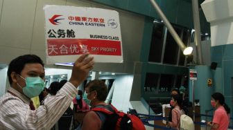 Petugas bandara memanggil para penumpang pesawat maskapai China Eastern menuju Shanghai China untuk melakukan boarding di Terminal 3 Bandara Soekarno Hatta, Tangerang, Banten, Rabu (5/2). [ANTARA FOTO/Muhammad Iqbal]