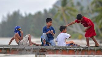 Sejumlah anak bermain di atas Dermaga Pengadah, Natuna, Kepulauan Riau, Jumat (7/2). [ANTARA FOTO/M Risyal Hidayat]
