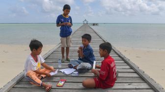 Sejumlah anak bersiap untuk menggambar di atas Dermaga Pengadah, Natuna, Kepulauan Riau, Jumat (7/2).  [ANTARA FOTO/M Risyal Hidayat]