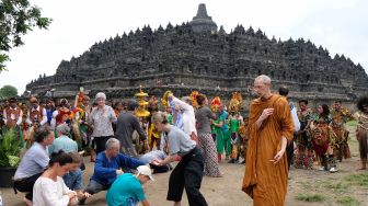 Sejumlah wisatawan asing pemerhati seni budaya melakukan olah gerak tubuh saat Ruwat Rawat Borobudur di kompleks Taman Wisata Candi (TWC) Borobudur, Magelang, Jawa Tengah, Minggu (9/2). [ANTARA FOTO/Anis Efizudin]