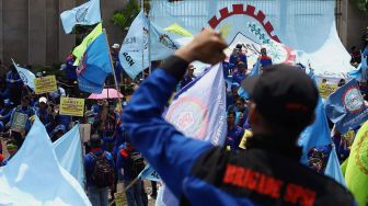 Massa buruh melakukan aksi unjuk rasa di depan Gedung DPR RI, Jakarta, Rabu (12/2). [Suara.com/Angga Budhiyanto]
