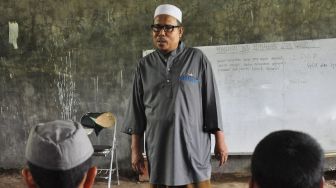 Pendiri Pondok Pesantren Al Hidayah yang merupakan mantan terpidana kasus terorisme Khairul Ghazali (tengah) memberikan pelajaran kepada santri yang merupakan anak mantan teroris, di Deli Serdang, Sumatera Utara, Rabu (12/2). [ANTARA FOTO/Septianda Perdana]