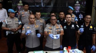 Kabid Humas Polda Metro Jaya Kombes Pol Yusri Yunus (tengah) didampingi Kapolres Jakarta Barat Kombes Pol Audie S Latuheru (ketiga kiri) beserta jajaran menunjukkan barang bukti saat pengungkapan perkara jenis narkotika dan psikotropika di Polres Metro Jakarta Barat, Rabu (12/2). [Suara.com/Angga Budhiyanto] 
  