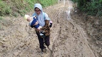 Viral Guru Gendong Bayi Lewati Jalan Berlumpur Demi Mengajar di Sekolah