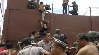 Petugas gabungan membawa narapidana pascakerusuhan di Rumah Tahanan Negara (Rutan) Kelas II B Kabanjahe, Kabupaten Karo, Sumatera Utara, Rabu (12/2). [ANTARA FOTO/Hasan]